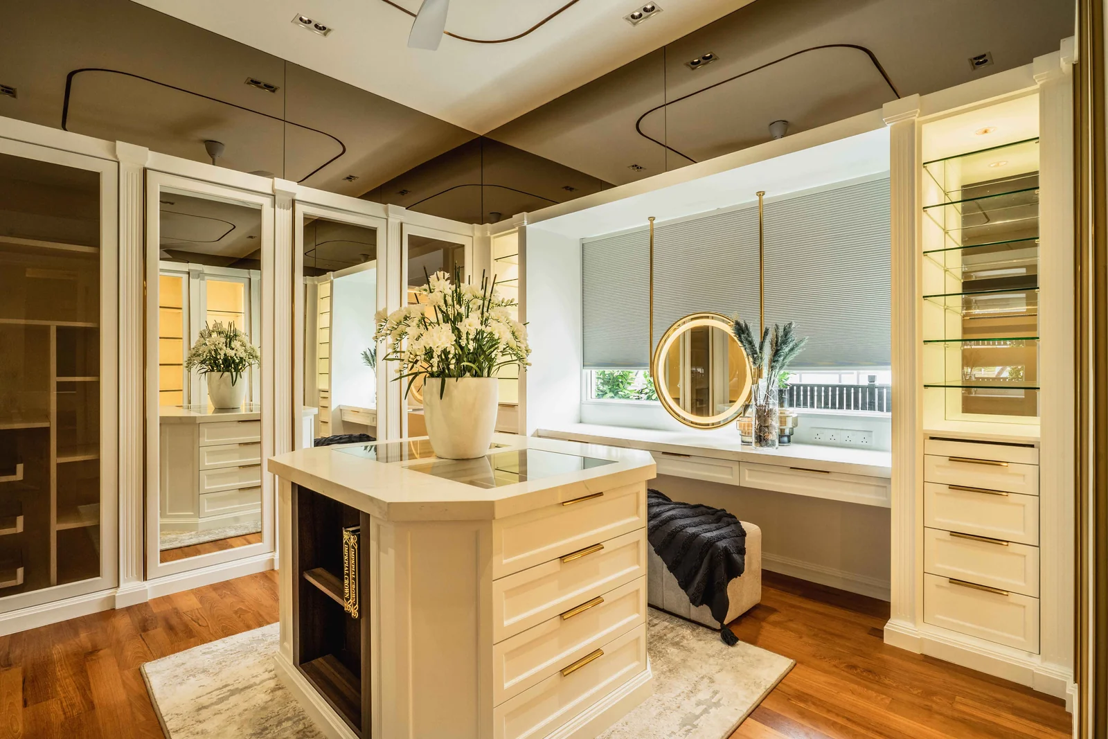 Lavish walk in wardrobe with a central island and glass display cabinets in a Blaine Robert Design bungalow at Eco Spring, Johor