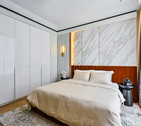 White handleless floor-to-ceiling wardrobe beside the bed in a master bedroom at Aira Residence, Damansara Heights, by Blaine Robert Design