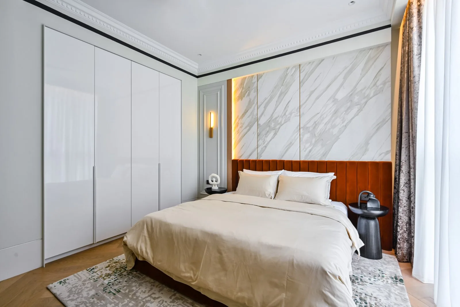 White handleless floor-to-ceiling wardrobe beside the bed in a master bedroom at Aira Residence, Damansara Heights, by Blaine Robert Design