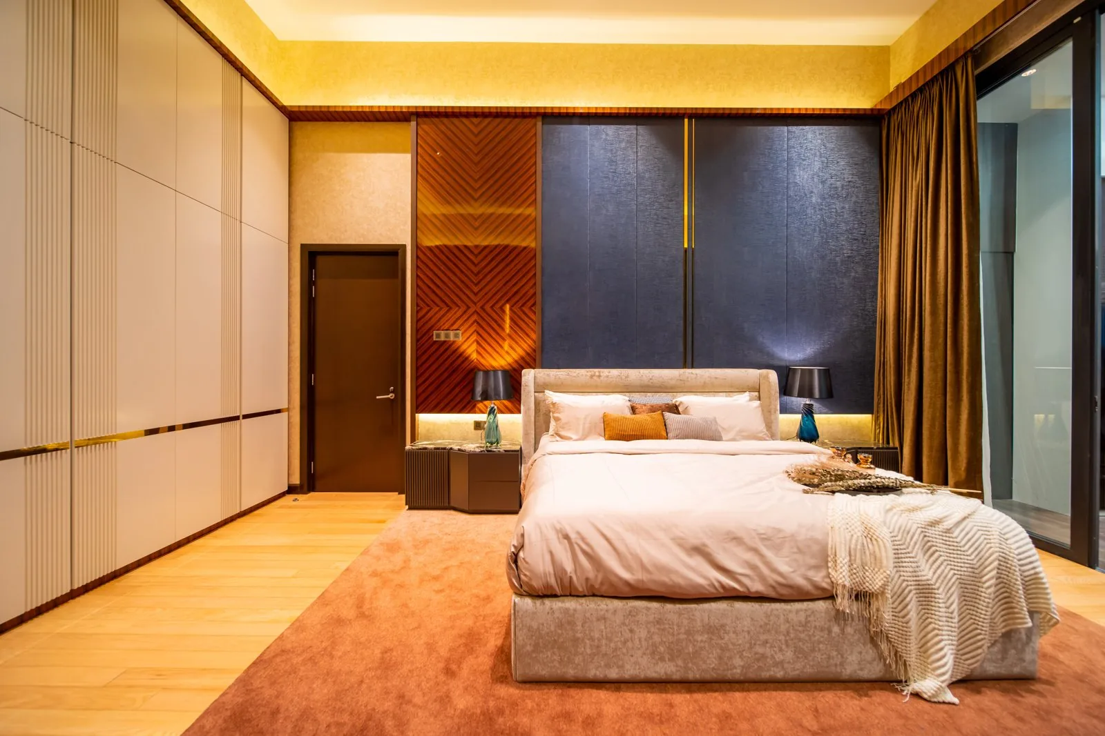 Floor to ceiling wardrobes in pale flat panels with brass reveal lines in the master bedroom of a Bangsar bungalow by Blaine Robert Design