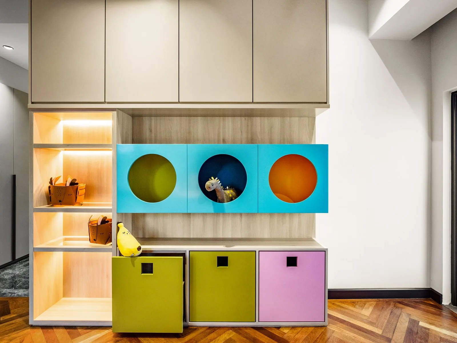 Colourful children's wardrobe and storage unit with round-window doors in lime, sky blue and pink in a Terengganu bungalow by Blaine Robert Design