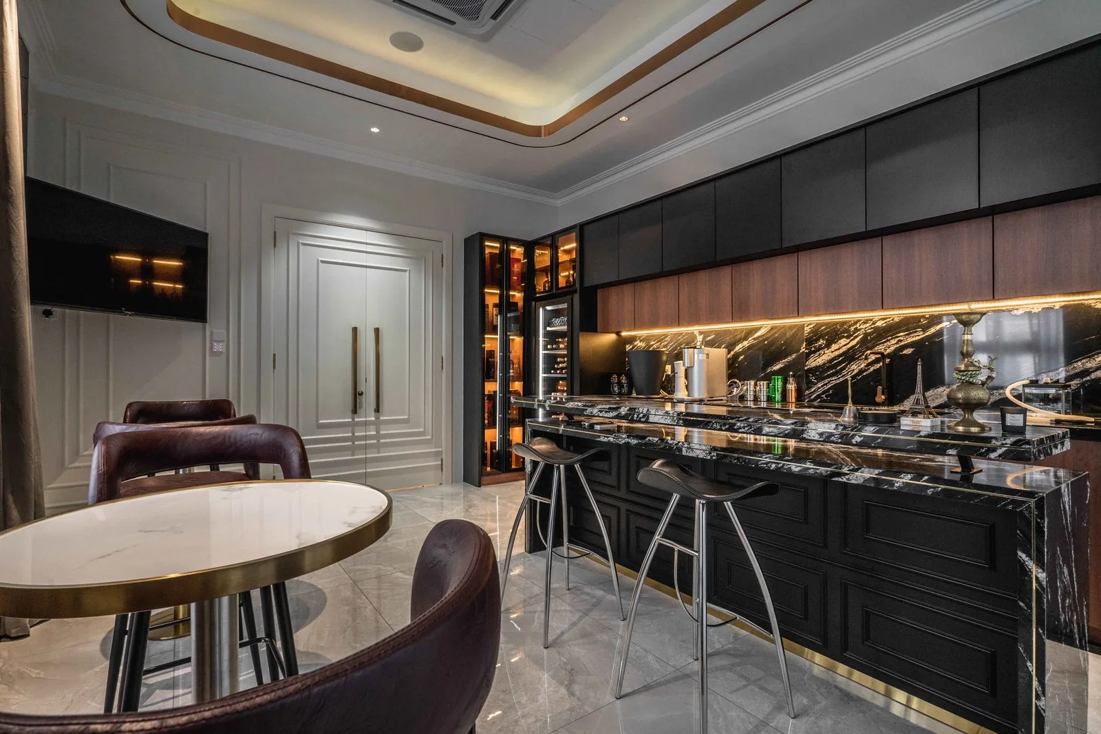 Dry kitchen with a black marble bar, wine storage and backlit glass cabinets in an EcoSpring villa in Johor Bahru